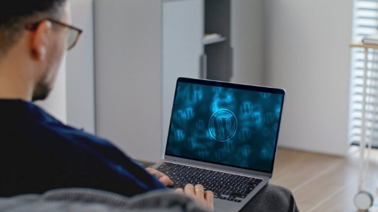 A man views a laptop screen displaying the WordPress logo, representing work related to choosing WordPress fonts for website design
