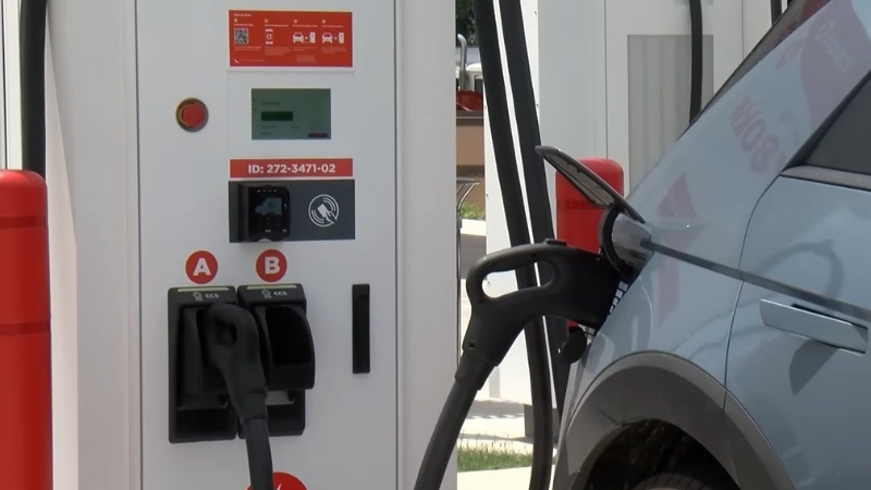 The Image Shows an Electric Car Charging at A Station