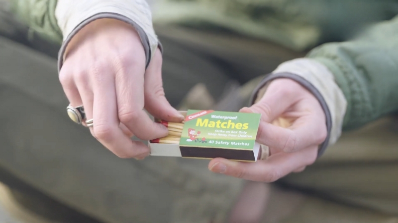 A Person Holding a Box of Waterproof Safety Matches, Ready for Use in A Survival Situation