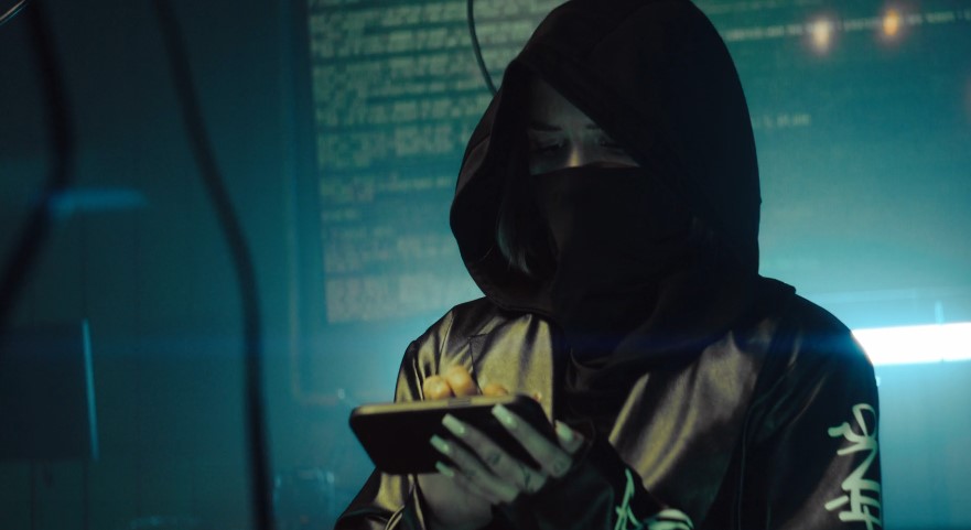 Close-up view of hacker using a mobile device