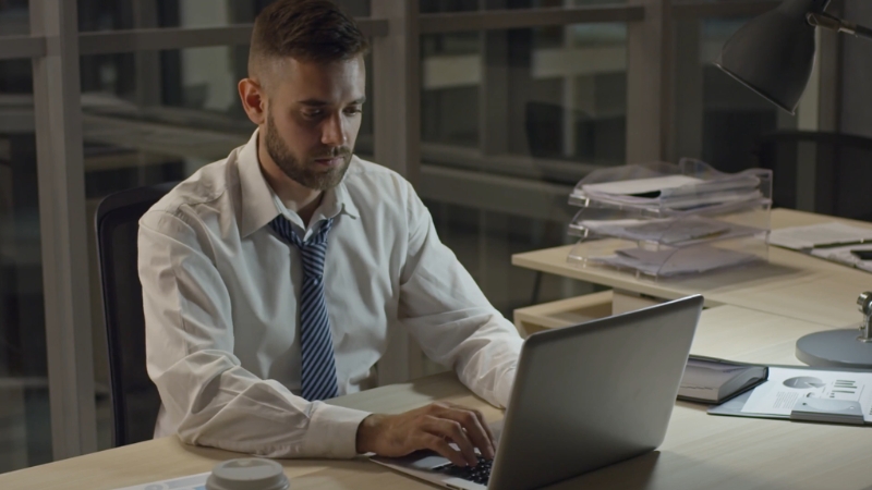 A man works late at his desk, focusing on aligning IT priorities with business objectives through detailed planning