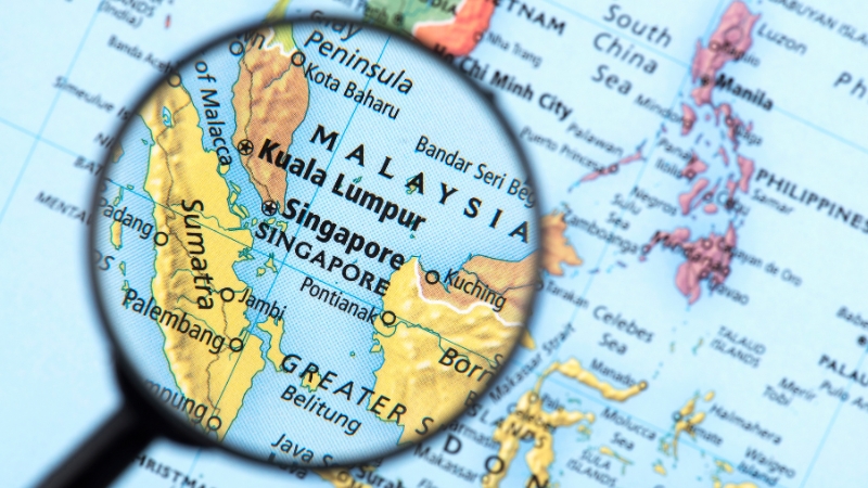 A magnifying glass shows Singapore on a map, highlighting it as a hub for online business in Asia