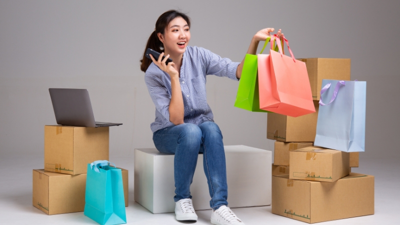 A woman with shopping bags and boxes shows the rise of online business in Asia