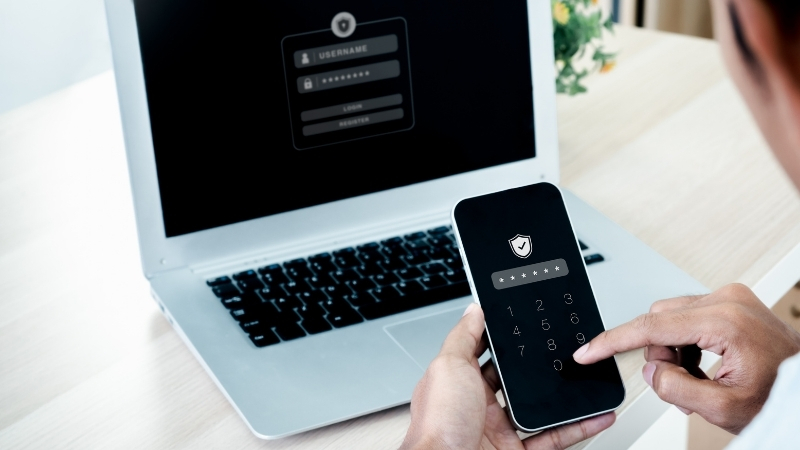 Person confirms a 2FA login on a phone while signing in on a laptop