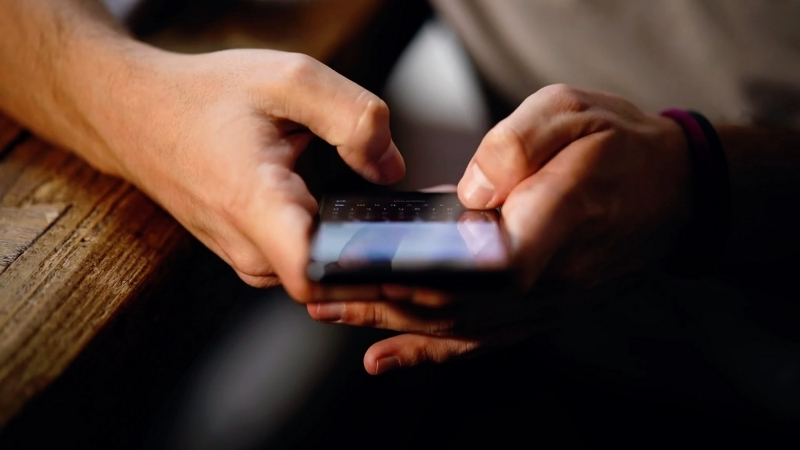 Person types an SMS one-time code on a phone to confirm account login